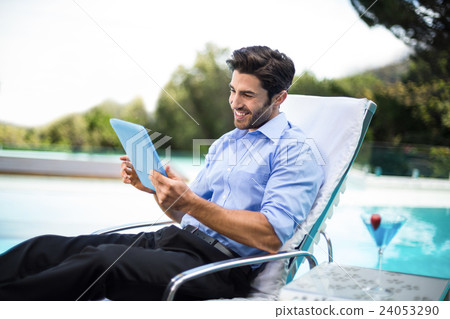 Smart man using digital tablet near pool Smart man using digital tablet near pool 24053290