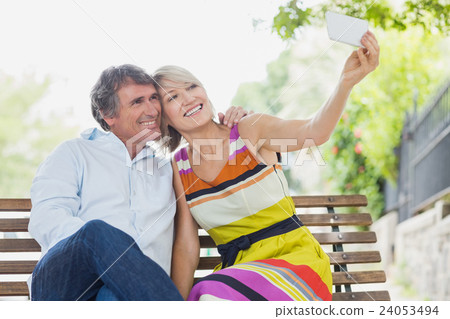 Couple taking selfie in park Couple taking selfie in park 24053494
