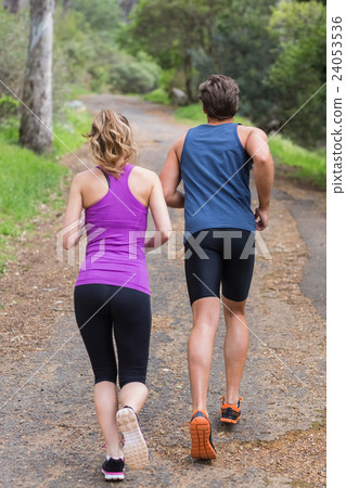 Rear view of couple jogging on road Rear view of couple jogging on road 24053536