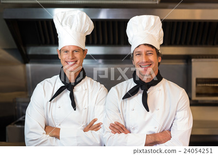 Portrait of smiling male chefs in kitchen Portrait of smiling male chefs in kitchen 24054251