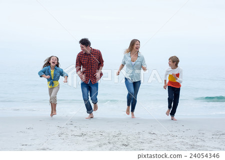 Cheerful family running at sea shore against sky Cheerful family running at sea shore against sky 24054346