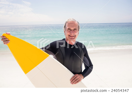 Portrait of senior man in wetsuit holding a surfboard Portrait of senior man in wetsuit holding a surfboard 24054347