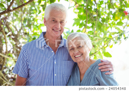 Smiling senior couple with arm around Smiling senior couple with arm around 24054348