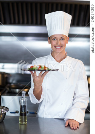 Portrait of smiling female chef holding food plate Portrait of smiling female chef holding food plate 24054399