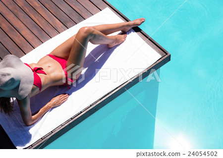 Woman enjoying sunbath on the pool edge Woman enjoying sunbath on the pool edge 24054502