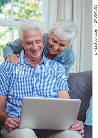 Smiling senior couple using laptop Smiling senior couple using laptop 24054503
