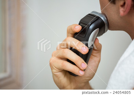 Mid-section of man shaving with trimmer Mid-section of man shaving with trimmer 24054805