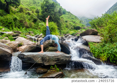 Woman doing yoga asana at waterfall 24055716