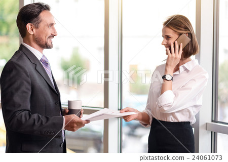 Cheerful colleagues holding papers Cheerful colleagues holding papers 24061073
