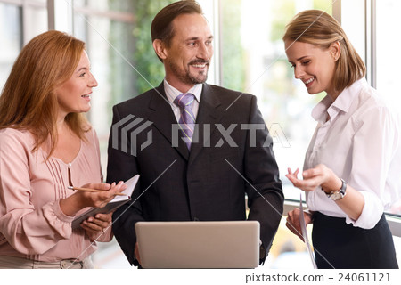 Cheerful colleagues discussing project. Cheerful colleagues discussing project. 24061121