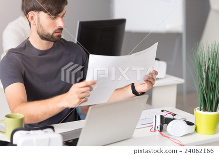 Concentrated man working with papers Concentrated man working with papers 24062166