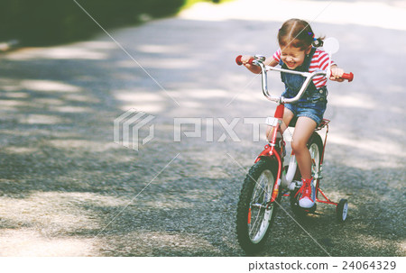 happy child girl cyclist riding a bike happy child girl cyclist riding a bike 24064329