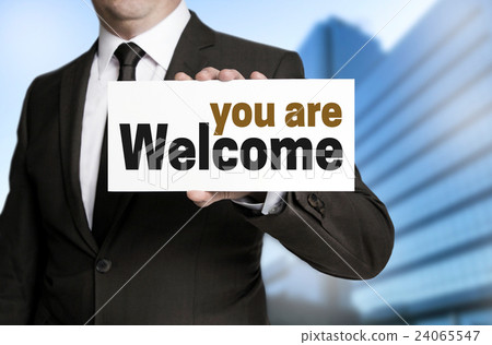you are welcome sign is held by businessman you are welcome sign is held by businessman 24065547