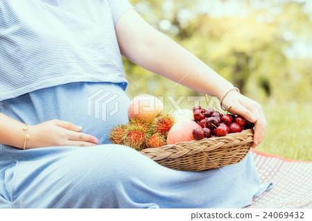 Pregnant woman and healthy fruit in garden. 24069432