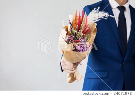 Young man in fashionable suit holding bouquet Young man in fashionable suit holding bouquet 24071978