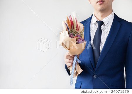 Young man in fashionable suit holding bouquet Young man in fashionable suit holding bouquet 24071979
