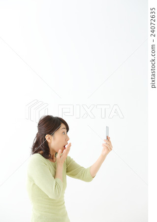 A woman watching a smartphone A woman watching a smartphone 24072635