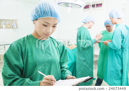 woman Surgeons writing medical record with teams 24073449