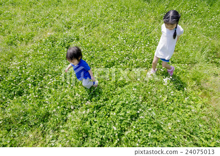 My older sister and brother playing in a fresh green park 24075013