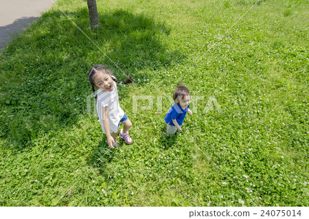 My older sister and brother playing in a fresh green park 24075014