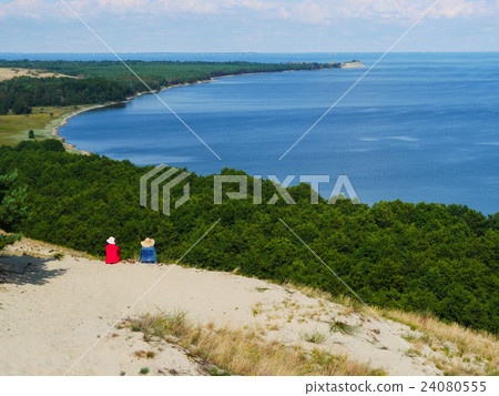 two friends contemplate panoramic view of sea 24080555