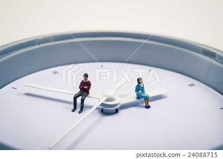 A man and a woman sitting on a watch A man and a woman sitting on a watch 24088715