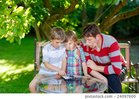 Two little kid boys and father playing together Two little kid boys and father playing together 24097600