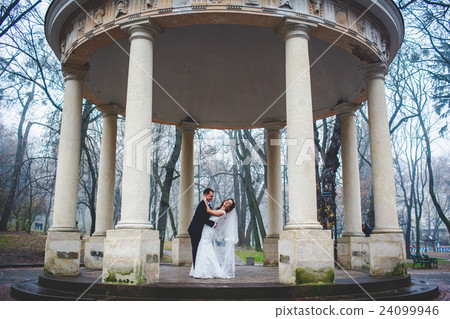 Groom bends bride over standing under Groom bends bride over standing under 24099946