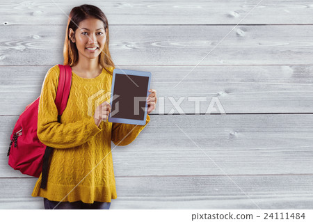 Composite image of smiling asian female student showing tablet Composite image of smiling asian female student showing tablet 24111484