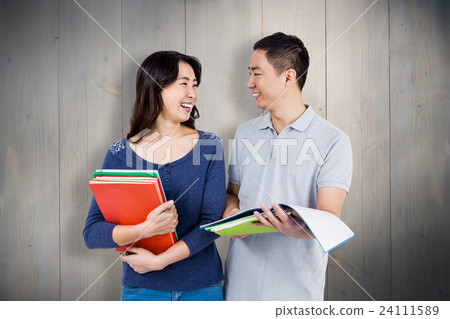 Composite image of couple smiling at each other while holding books 24111589