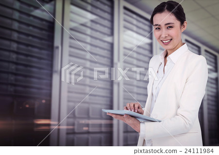 Composite image of smiling businesswoman using her tablet 24111984