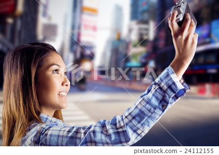 Composite image of smiling asian woman taking picture with camera 24112155