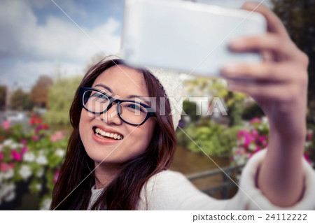 Composite image of smiling asian woman taking selfie Composite image of smiling asian woman taking selfie 24112222