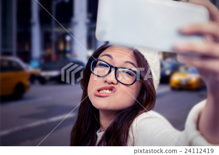 Composite image of asian woman making faces and taking selfie 24112419