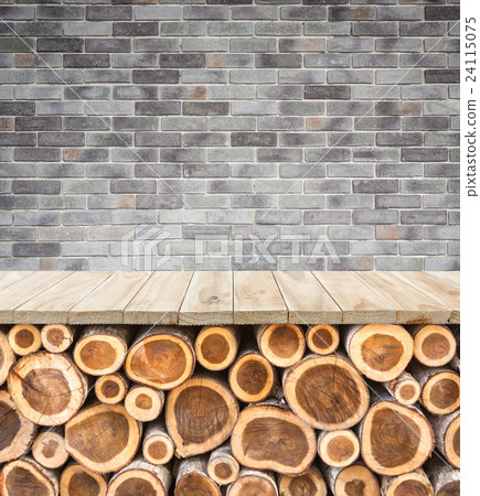 Empty top of wooden table or counter with pile wood log and stone wall. Interior decoration for product display Empty top of wooden table or counter with pile wood log and stone wall. Interior decoration for product display 24115075