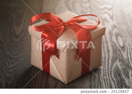 rustic present box with red ribbon on wood table 24119857