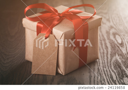 rustic present box with red ribbon on wood table rustic present box with red ribbon on wood table 24119858