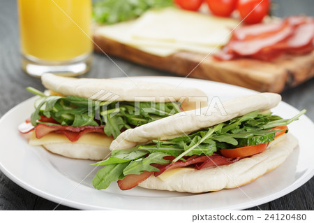 rustic sandwiches with ham arugula and tomatoes 24120480