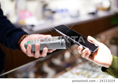 Female paying with NFC technology on smart phone 24131024