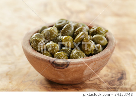 marinated capers in olive bowl on wood table marinated capers in olive bowl on wood table 24133748