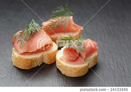 baguette slices with curred salmon on slate 24133840