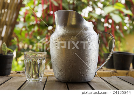 A Glass and Metal Jug of water A Glass and Metal Jug of water 24135844