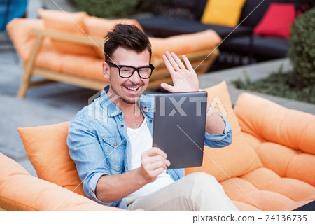 Cheerful man talking through the Internet Cheerful man talking through the Internet 24136735