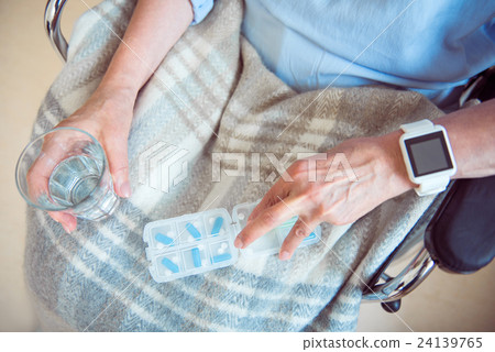 Senior female patient taking pills 24139765