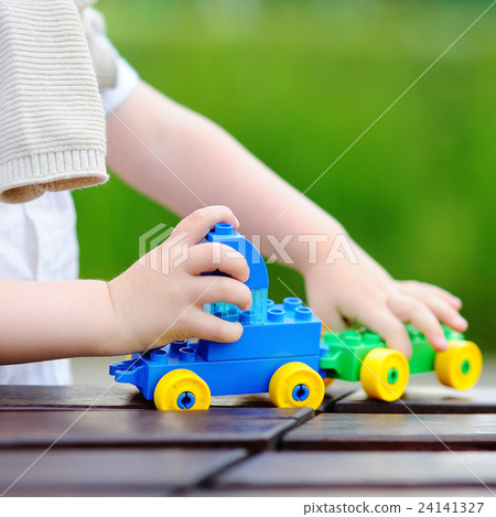 Toddler boy playing with toy train 24141327