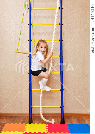 Little girl climbs stairs holding on to rope. Little girl climbs stairs holding on to rope. 24146316