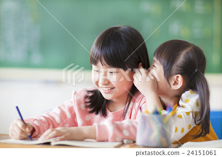 Two young girls whispering and sharing a secret Two young girls whispering and sharing a secret 24151061