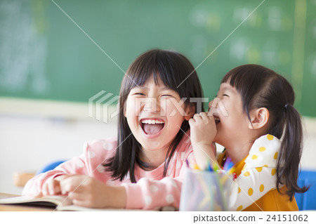 Laughing little girls sharing secrets in class Laughing little girls sharing secrets in class 24151062