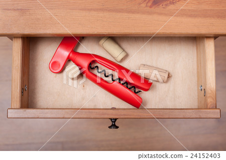 red corkscrew and cork from wine bottles in drawer red corkscrew and cork from wine bottles in drawer 24152403