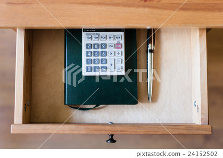 pen, calculator and notebook in open drawer pen, calculator and notebook in open drawer 24152502